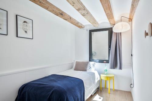 a white bedroom with a bed and a window at Inside Barcelona Apartments Esparteria in Barcelona