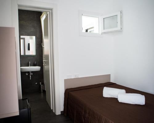 マリーナ・ディ・ラグーザにあるRegina's Homeのベッドルーム1室(ベッド1台、タオル2枚付)