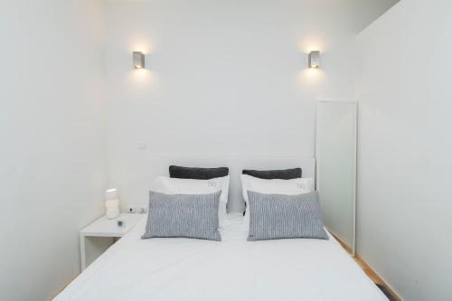 a bed with a white comforter and pillows at BO - Almada in Porto