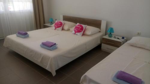 a bedroom with two beds with pink and purple pillows at Beautiful Apartment Jukic in Podstrana