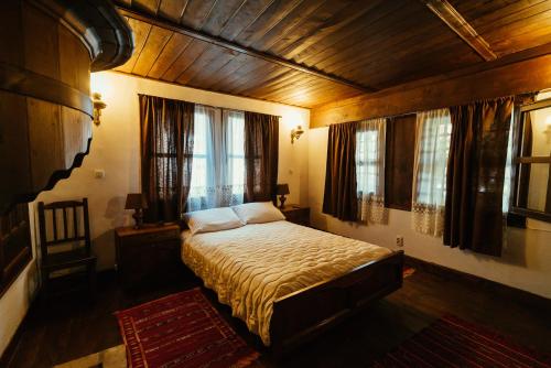a bedroom with a bed in a room with windows at Zoev House in Karlovo