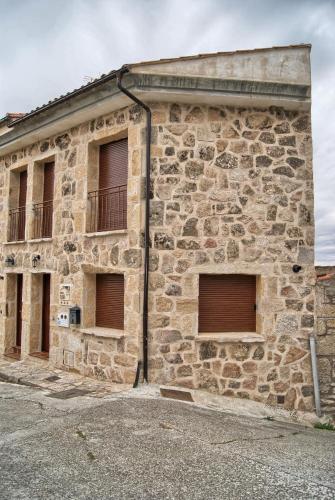 a stone building with three windows and a balcony at Casa Rural Buenaventura in Fermoselle