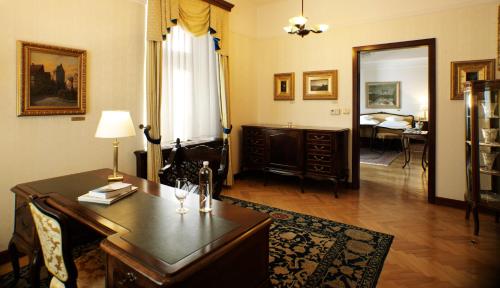 a living room with a desk and a bedroom at Grand Hotel Toplice - Small Luxury Hotels of the World in Bled