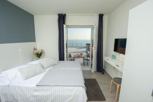 a bedroom with a bed and a view of the ocean at Seaside Luxury Suites in Podstrana