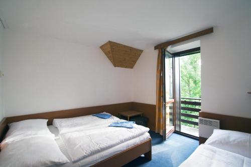 a bedroom with two beds and a large window at Horska chata Svetlanka in Rokytnice nad Jizerou
