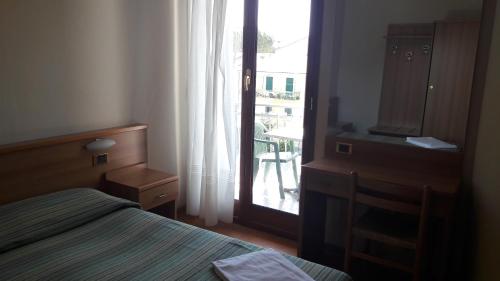a bedroom with a bed and a door to a balcony at Hotel Residence Moneglia in Moneglia