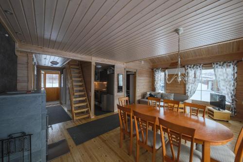 - une salle à manger et un salon avec une table et des chaises dans l'établissement Arctic Aurora Borealis cottages, à Nuorgam