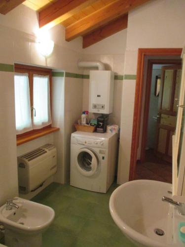 a bathroom with a washing machine and a sink at Appartamento del Sole in Gaby