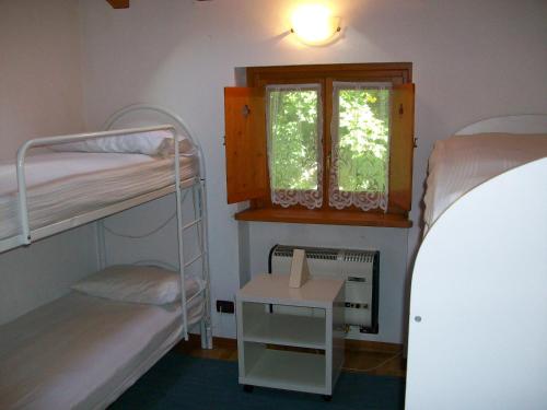 a bedroom with two bunk beds and a window at Appartamento del Sole in Gaby