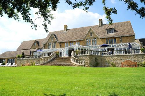 an exterior view of a large brick house with a large lawn at Cricklade House Hotel, Sure Hotel Collection by Best Western in Cricklade