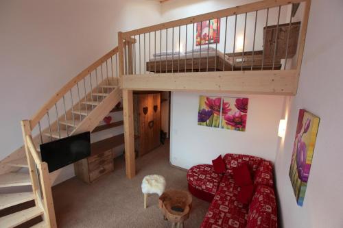 a living room with a staircase and a couch at Brunnenhof Oberstdorf - Ferienwohnungen mit Hotel Service in Oberstdorf
