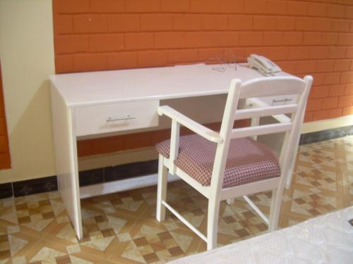a white desk with a chair next to a wall at Kakakuona Resort in Lushoto