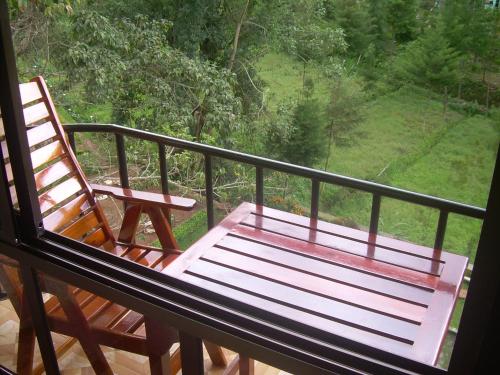 a bench sitting on a balcony with a view at Kakakuona Resort in Lushoto