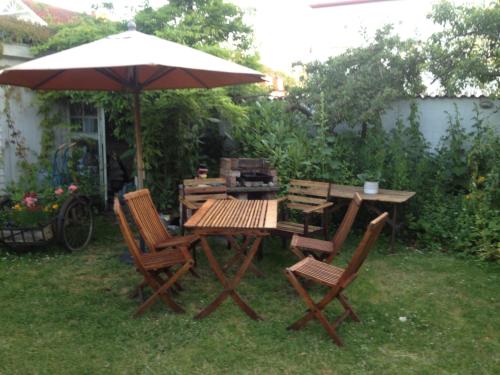 a wooden table and chairs under an umbrella at Villa Verdi in Borgholm