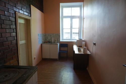 una cocina con fregadero y una ventana en una habitación en Pilskalnu hostelis en Kuldīga