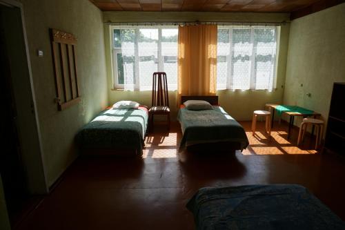 a room with three beds and a window at Pilskalnu hostelis in Kuldīga