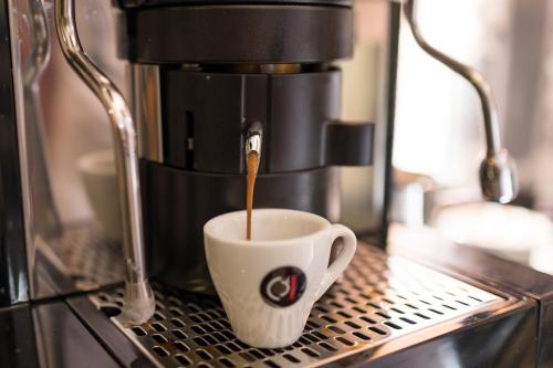 a coffee maker is making a cup of coffee at Beatus Suites And Rooms B&B in Canicattì