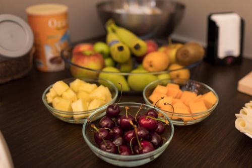 three bowls of fruit on a table with bowls of fruit at Beatus Suites And Rooms B&B in Canicattì