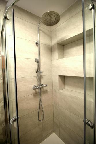 a shower with a glass door in a bathroom at Apartamenty Podgorze in Szklarska Poręba