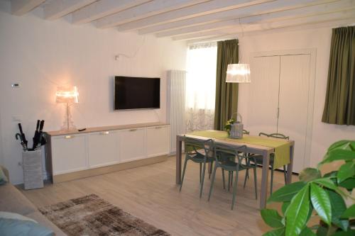 a living room with a table and a television on the wall at Verona White Lodge in Verona
