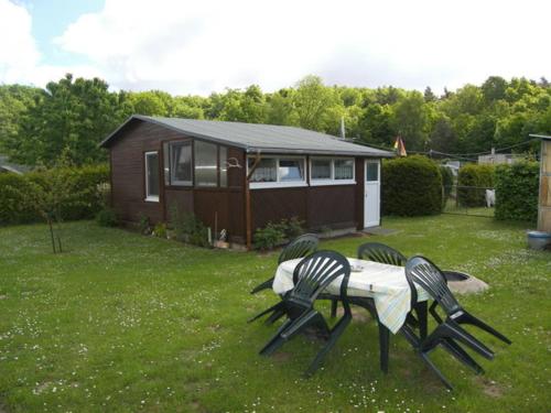 a table and chairs in a yard with a cabin at Bungalow am Schmollensee in Sellin