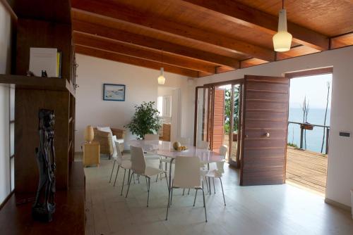 une salle à manger avec une table et des chaises blanches dans l'établissement Casa Paradiso, à Terracine