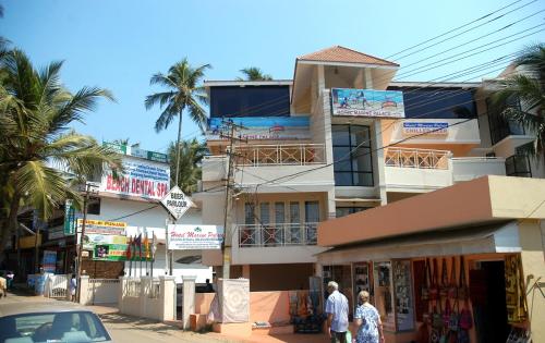two people walking down a street in front of a building at Marine Palace Beach Hotel in Kovalam