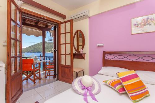 a bedroom with a bed and a balcony at Ionio Sea Poros Studios in Mikros Gialos