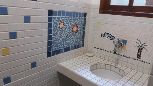 a bathroom with a sink in a tiled room at Be Hospedagem in Lumiar