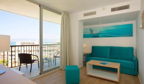a living room with a blue couch and a balcony at JS Palma Stay - Adults Only in Can Pastilla