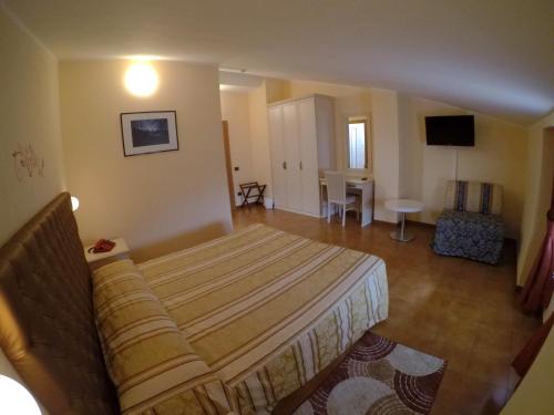 a bedroom with a bed and a living room at Hotel Ristorante Combolo in Teglio