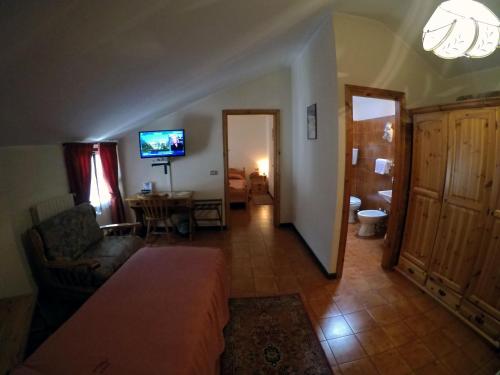 a living room with a couch and a television in a room at Hotel Ristorante Combolo in Teglio