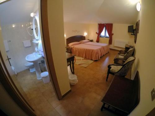 a view of a bedroom with a bed and a bathroom at Hotel Ristorante Combolo in Teglio