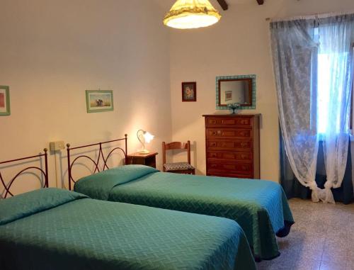 a bedroom with two green beds and a dresser at Due Piani in Barberino di Val dʼElsa