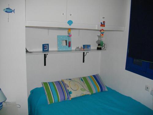 a room with a bed with a pillow and shelves at Superb view House-Sikinos Island-Chorio in Síkinos