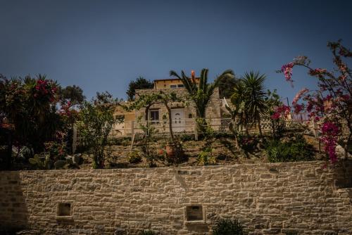 a house on top of a stone wall at Bodikos Villas & Apartments in Pitsidia