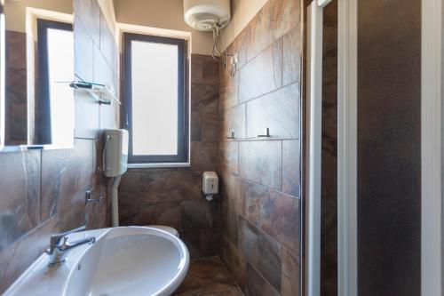 a bathroom with a sink and a window at Beatus Suites And Rooms B&B in Canicattì