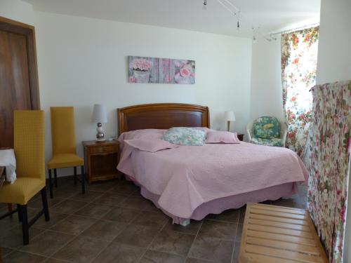 sypialnia z łóżkiem i 2 krzesłami w obiekcie La Source D'Argammet w mieście La Ferté