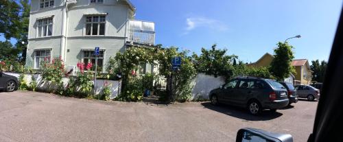 a car parked in front of a white house at Villa Verdi in Borgholm