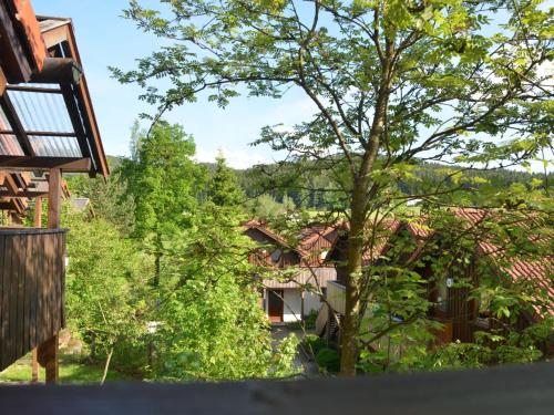 a tree in front of a building with trees at Ferienwohnung Wildgatter in Grafenwiesen