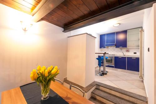 a kitchen with a vase of yellow flowers on a table at ReArduinoIvrea in Ivrea