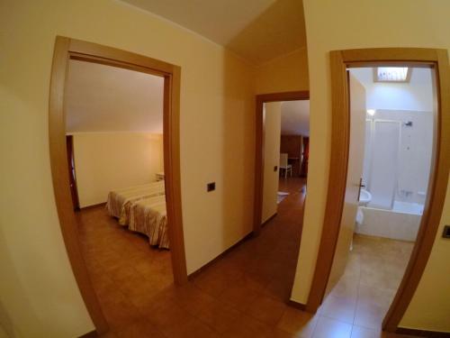 a view of a bedroom with a bed and a mirror at Hotel Ristorante Combolo in Teglio