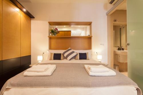 セビリアにあるArtist's Charming Design - Space Maison Apartmentsのベッドルーム1室(大型ベッド1台、タオル2枚付)