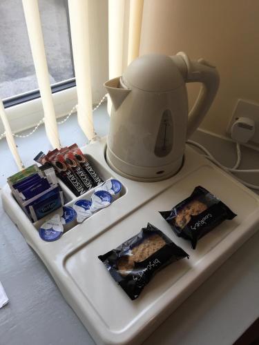 a white tray with food and a tea kettle at Belgrave Arms Hotel in Helmsdale