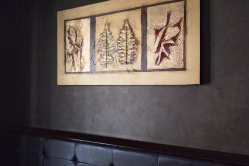 a framed picture of pine trees on a wall at Beatus Suites And Rooms B&B in Canicattì