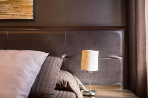a lamp sitting on a table next to a bed at Beatus Suites And Rooms B&B in Canicattì