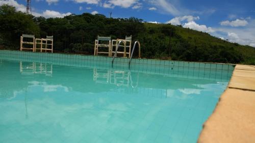 a swimming pool with chairs in the water at Hotel Madrid in Mendes