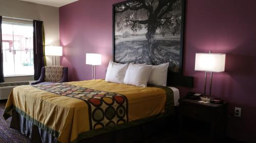 a hotel room with a bed and a chair at Super 8 by Wyndham Carrizo Springs in Carrizo Springs