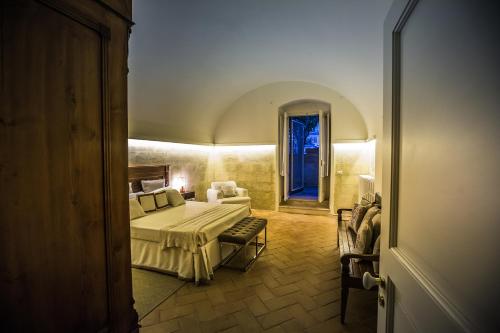 a bedroom with a bed and a couch in a room at Giardini 82 B&B in Gravina in Puglia