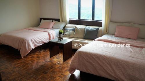 two beds in a room with a window at AFamosa Purple Dream Residence Condotel homestay in Melaka